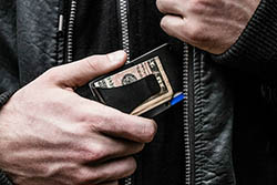 man putting wallet in pocket