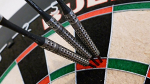 dartboard with steel tip darts thrown in